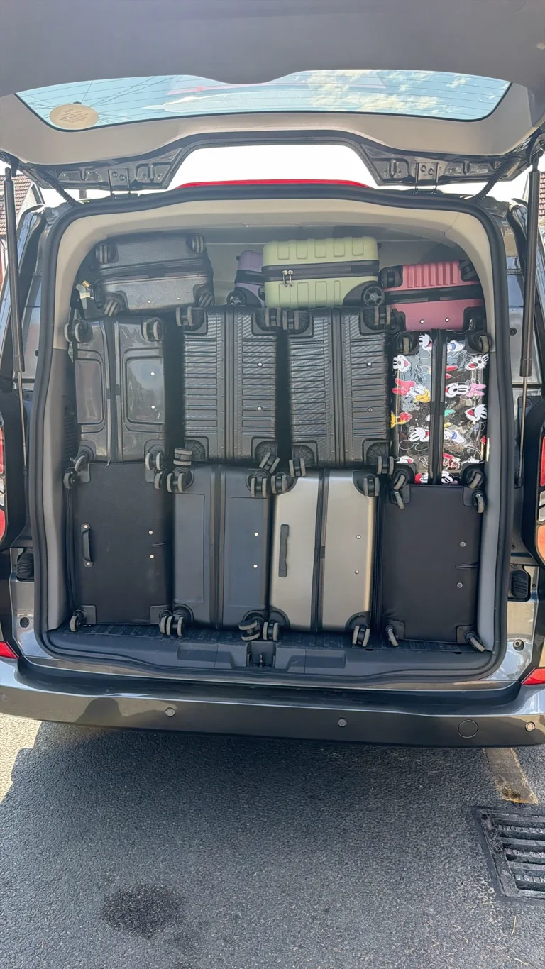 Real partner vehicle boot loaded with eight large suitcases and four cabin bags, with the count confirmed by Prime Airport Transfer